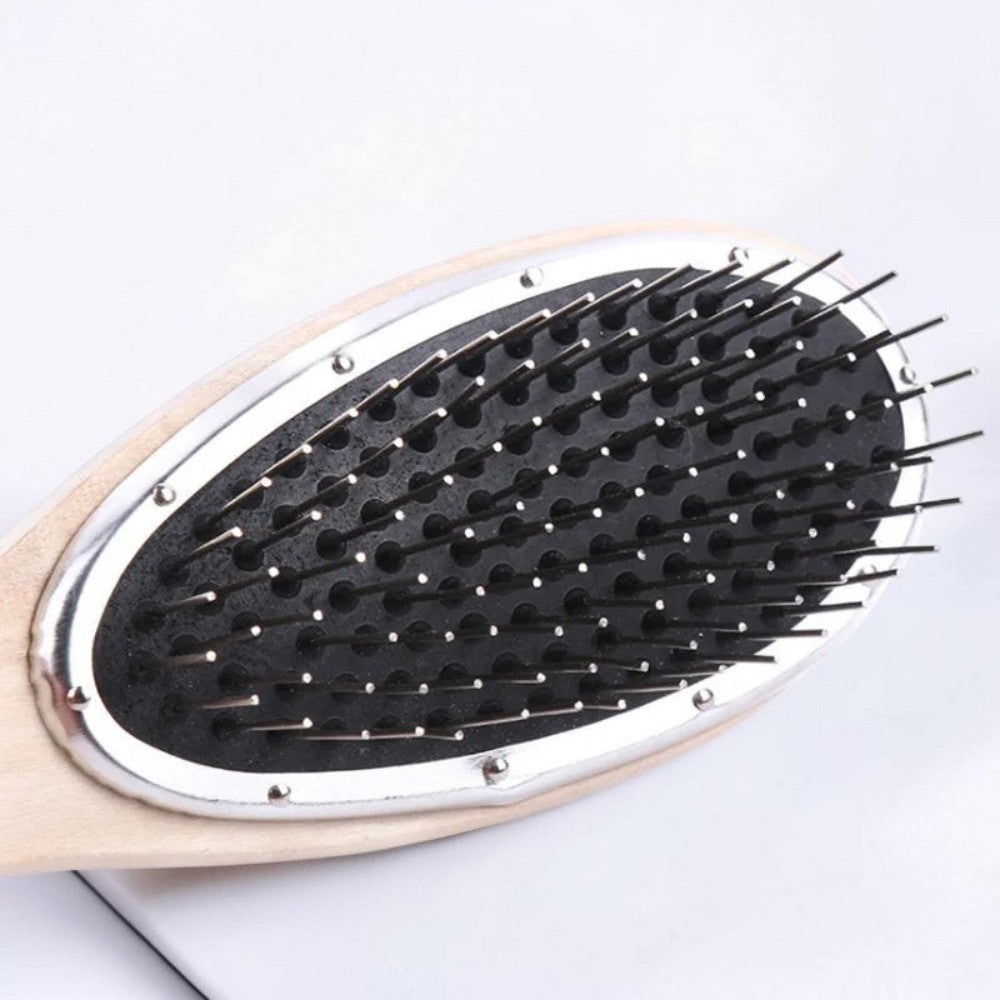 Hair extension detangling brush with metal bristles in a bright minimalist bathroom-style setting