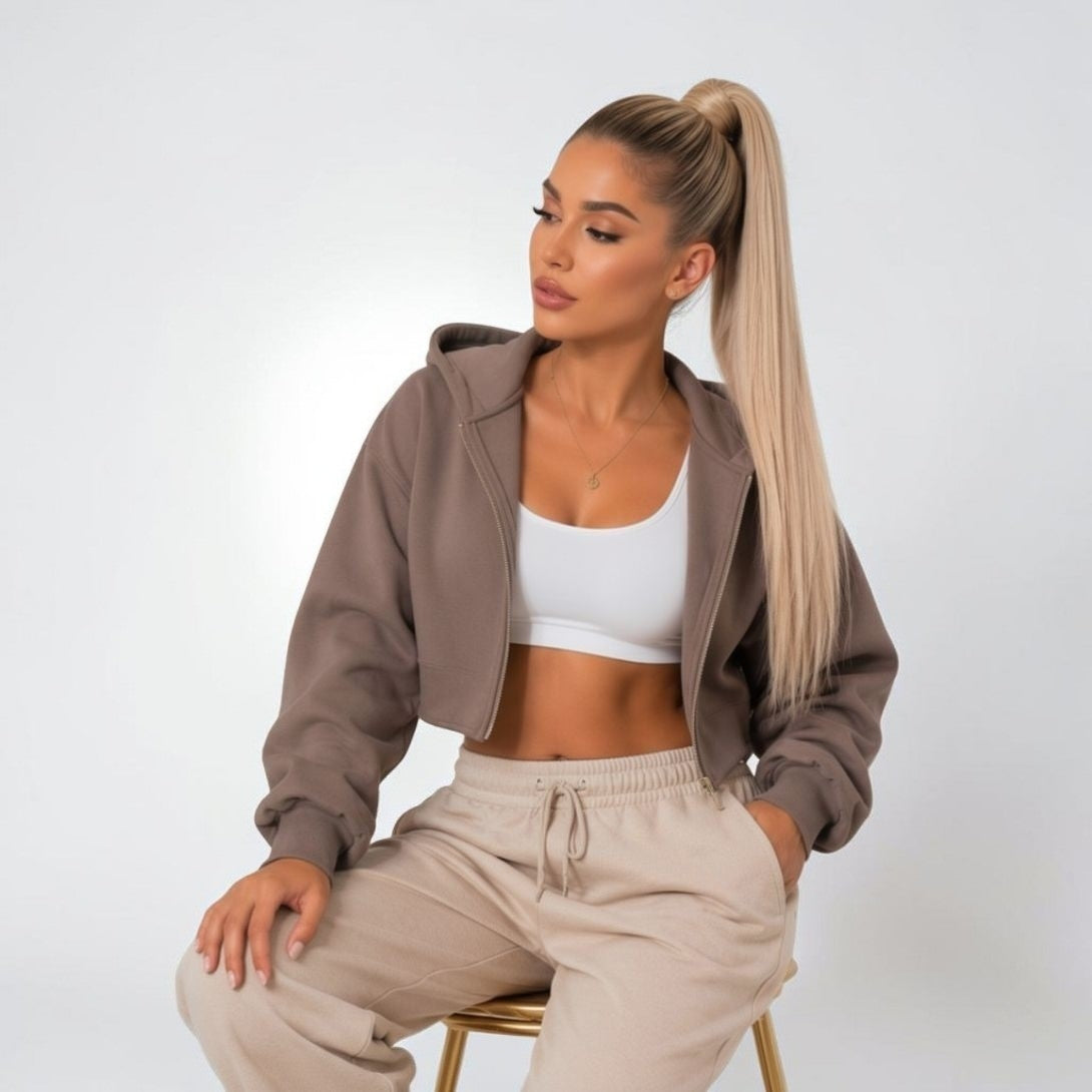 Model wearing an Icy Blonde 150g wrap-around ponytail extension, sleek high ponytail